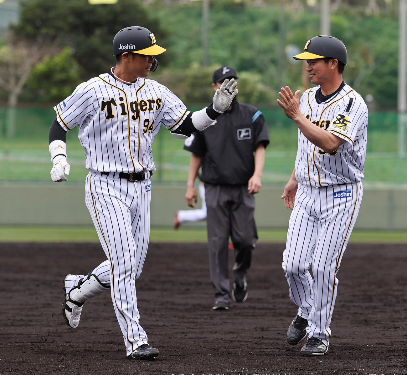 練習試合阪神対楽天　9回裏阪神1死二塁、サヨナラ打を放ち筒井コーチ（右）とタッチを交わす原口（撮影・清水貴仁）
