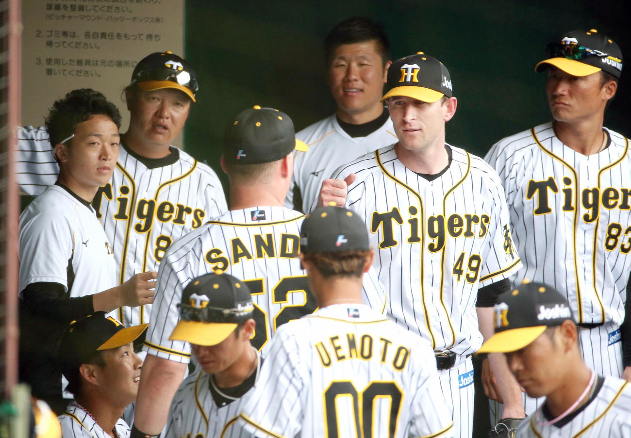練習試合阪神対楽天　ガンケル（右から2人目）は2回に好守備をみせたサンズ（左から3人目）とグータッチする（撮影・上山淳一）
