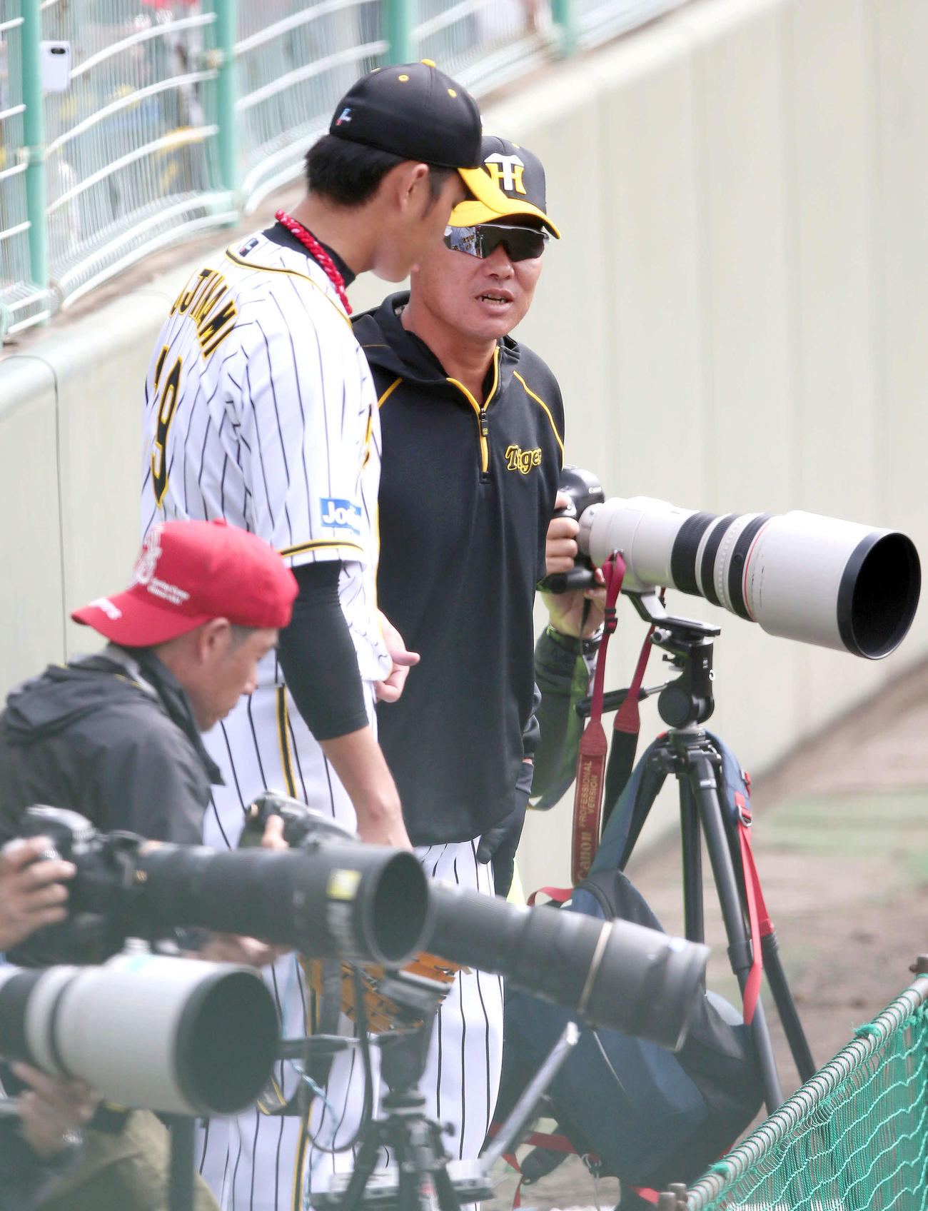 9日、カメラマン席で練習試合を見ていた福留（右）は投球を終えた藤浪と話す