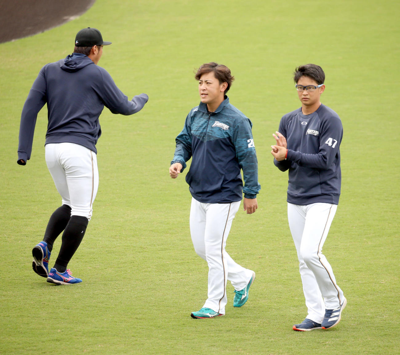 並んでウオーミングアップする日本ハム河野（中央）と鈴木健（右）（撮影・佐藤翔太）