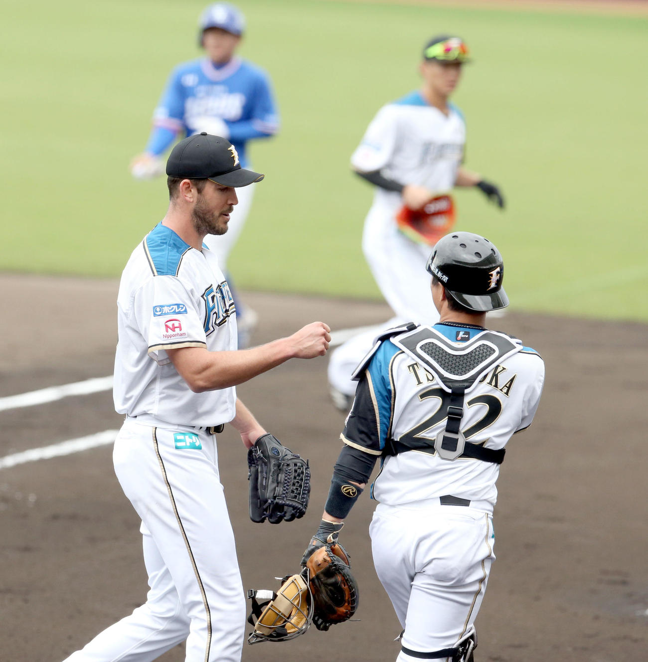 日本ハム対サムスン　2回表を無失点に抑えグータッチをしながらベンチに戻る日本ハム・バーヘイゲンと鶴岡（右手前）（撮影・佐藤翔太）