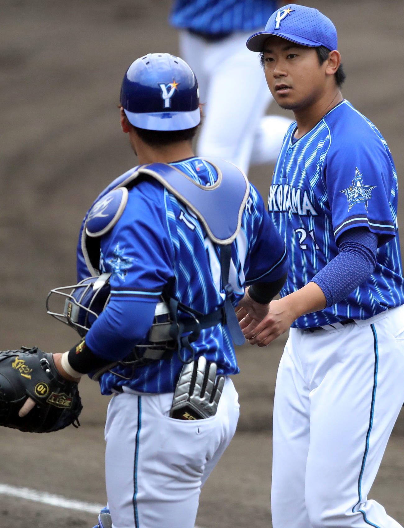 練習試合ヤクルト対DeNA　1回裏を終え、戸柱（左）と話をする今永（撮影・狩俣裕三）