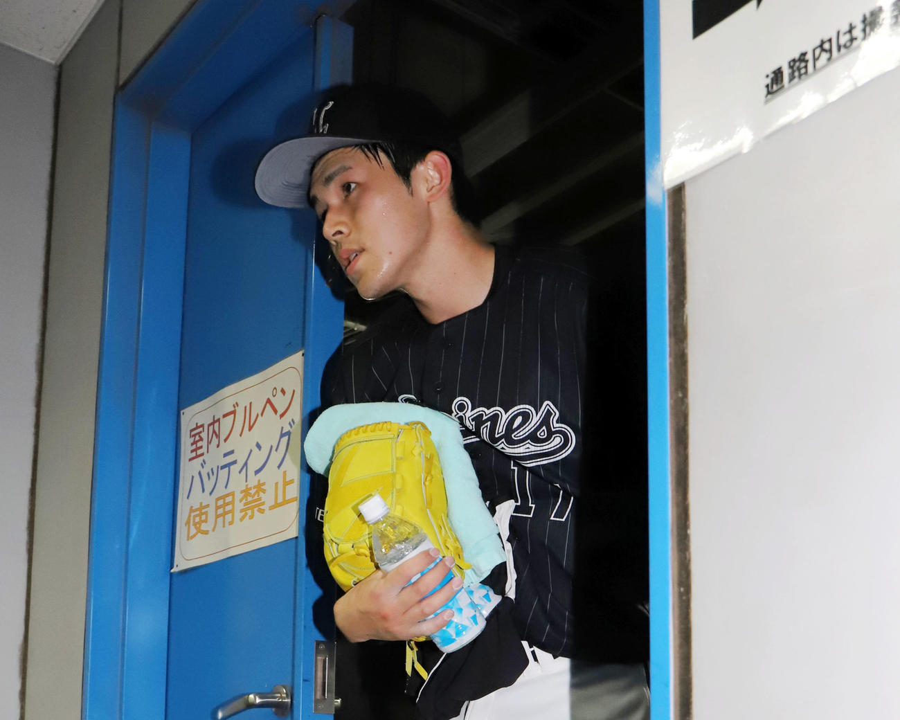 ブルペンで投球練習を終えたロッテ佐々木朗希は汗を流しながら引き揚げる（撮影・垰建太）