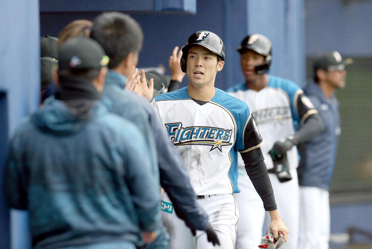 日本ハム対サムスン　7回裏日本ハム2死二、三塁、今井の2点適時打で生還しチームメートに出迎えられる片岡（撮影・佐藤翔太）