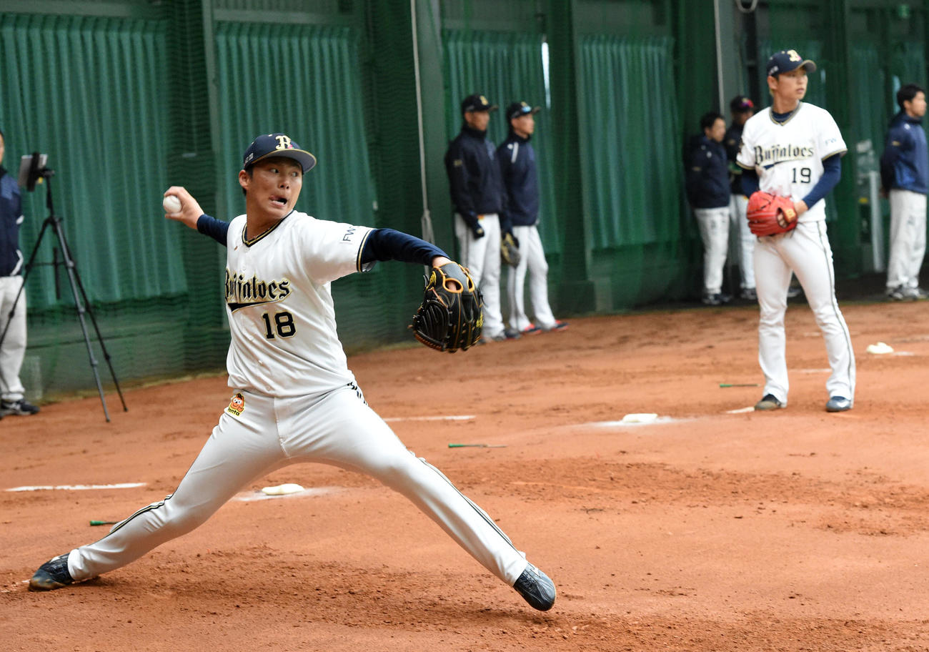 ブルペンで投球練習を行う山本（左）と山岡（2020年2月12日）
