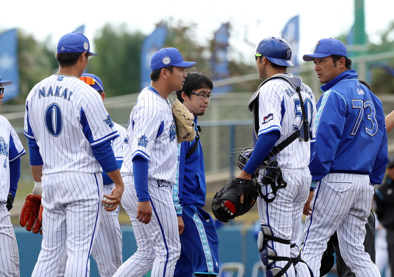 DeNA対ロッテ　9回表ロッテ1死、福田光の打球が左手に直撃した山崎（中央左）はスタッフの付き添われながらベンチ裏に下がる（撮影・垰建太）