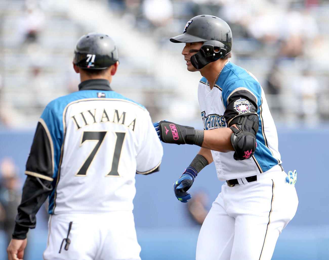 日本ハム対広島　4回裏日本ハム無死、左前打を放ち飯山コーチ（左手前）とタッチを交わす大田（撮影・佐藤翔太）