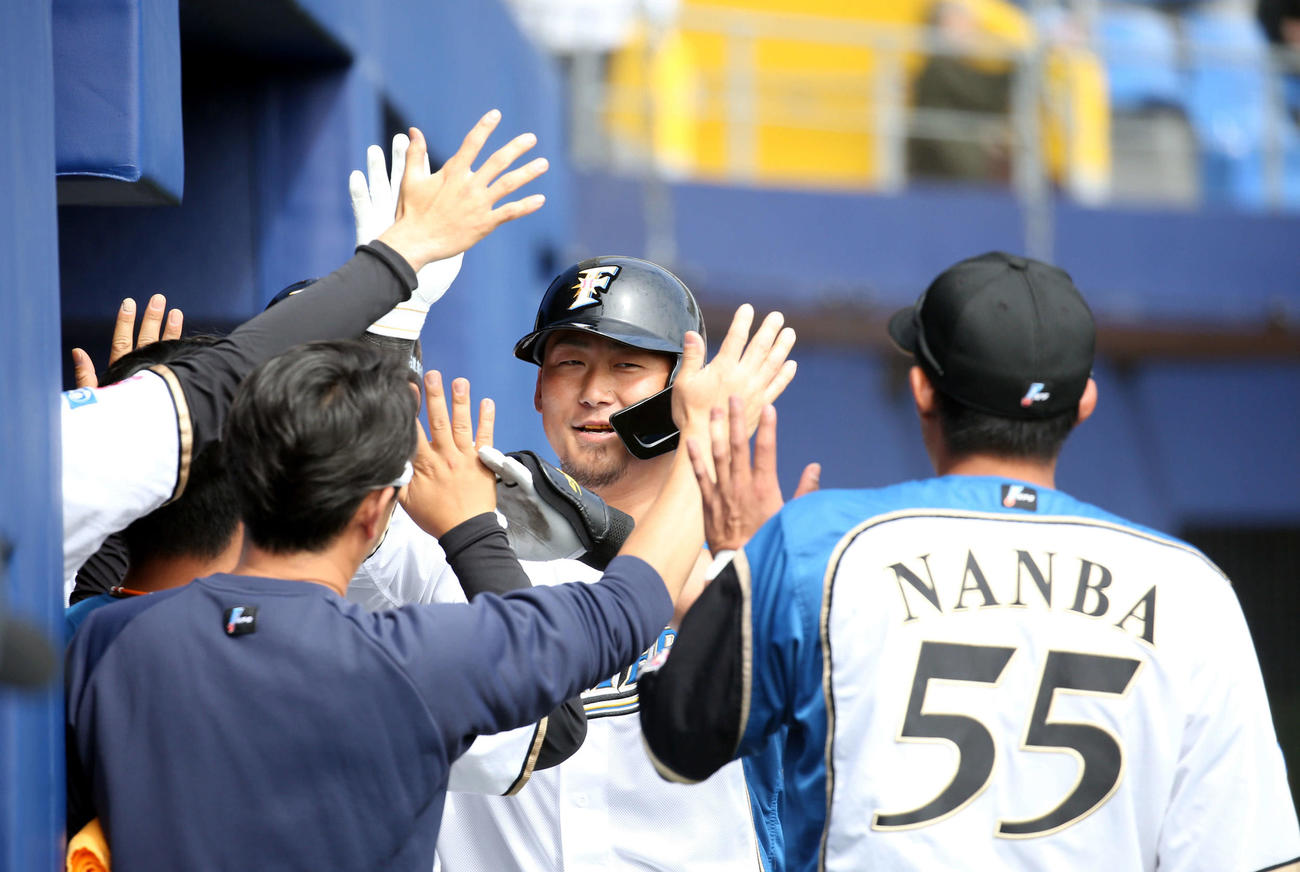 日本ハム対広島　4回裏日本ハム無死一塁、逆転となる右越え2点本塁打を放ちチームメートに出迎えられる中田（撮影・佐藤翔太）