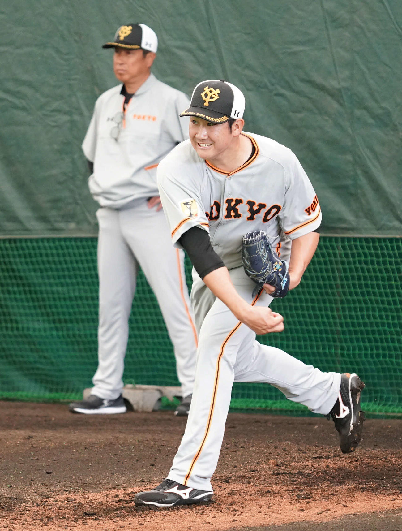 宮本投手チーフコーチ（後方）が見つめる前でブルペン投球する巨人菅野（撮影・加藤諒）