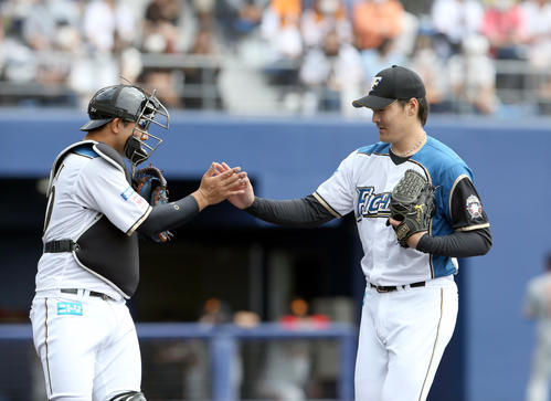 日本ハム対巨人　タッチを交わしながらベンチに戻る日本ハム宇佐見（左）と有原（撮影・佐藤翔太）