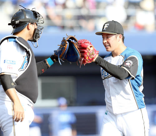 日本ハム対DeNA　9回表を無失点に抑えタッチを交わす日本ハム宇佐見（左）と吉田輝（撮影・佐藤翔太）