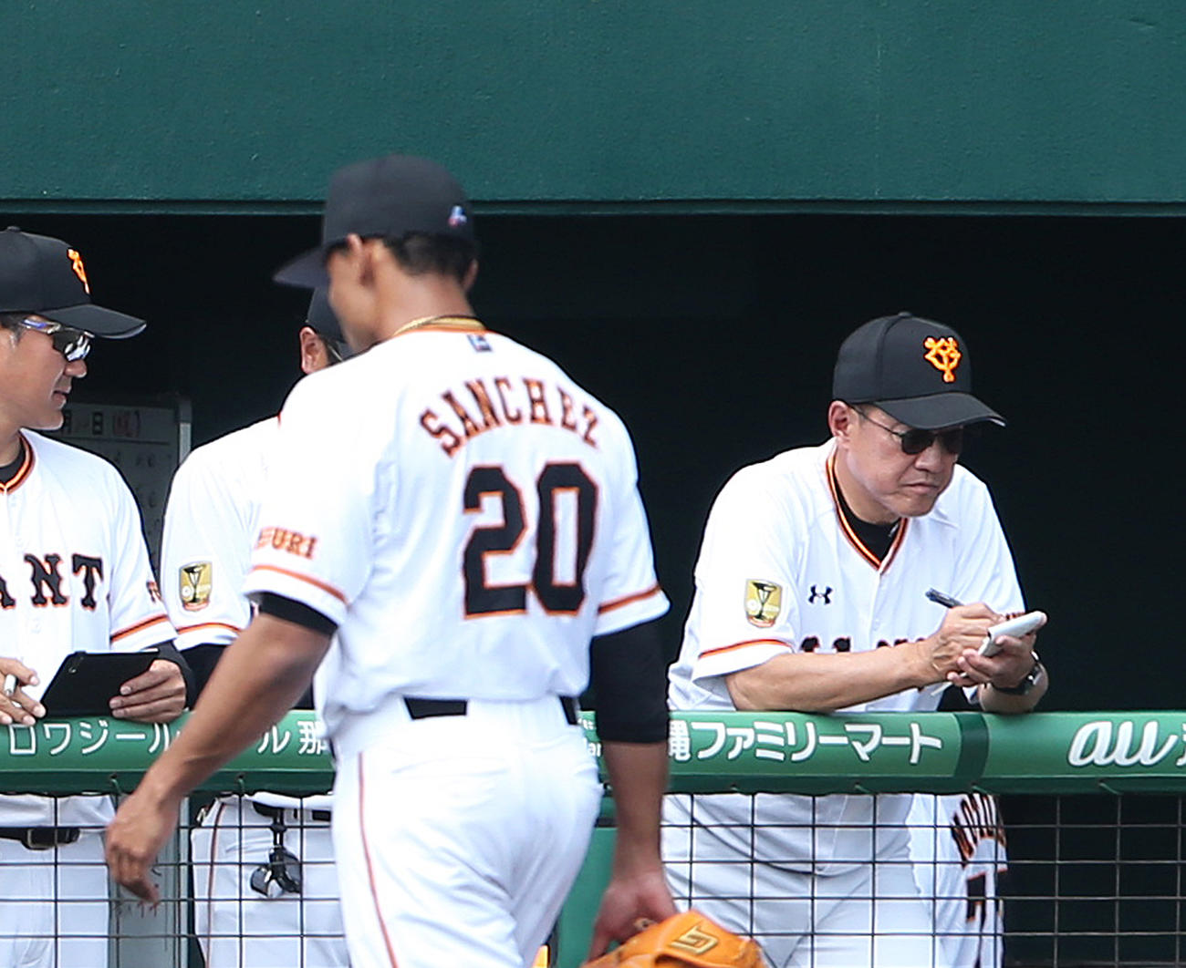 1回表を終え5失点のサンチェス（手前）が引き揚げる中、ベンチでメモをとる原監督（撮影・河野匠）