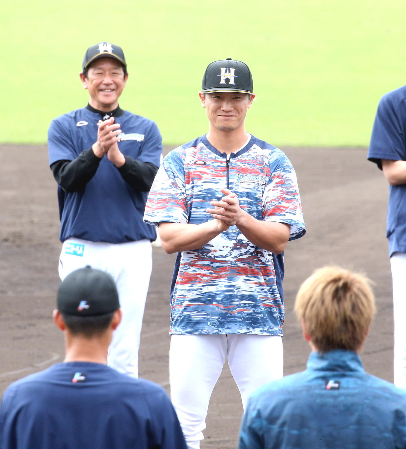 手締めのあいさつをし、一本締めをする日本ハム西川。左奥は笑顔の栗山監督（撮影・佐藤翔太）