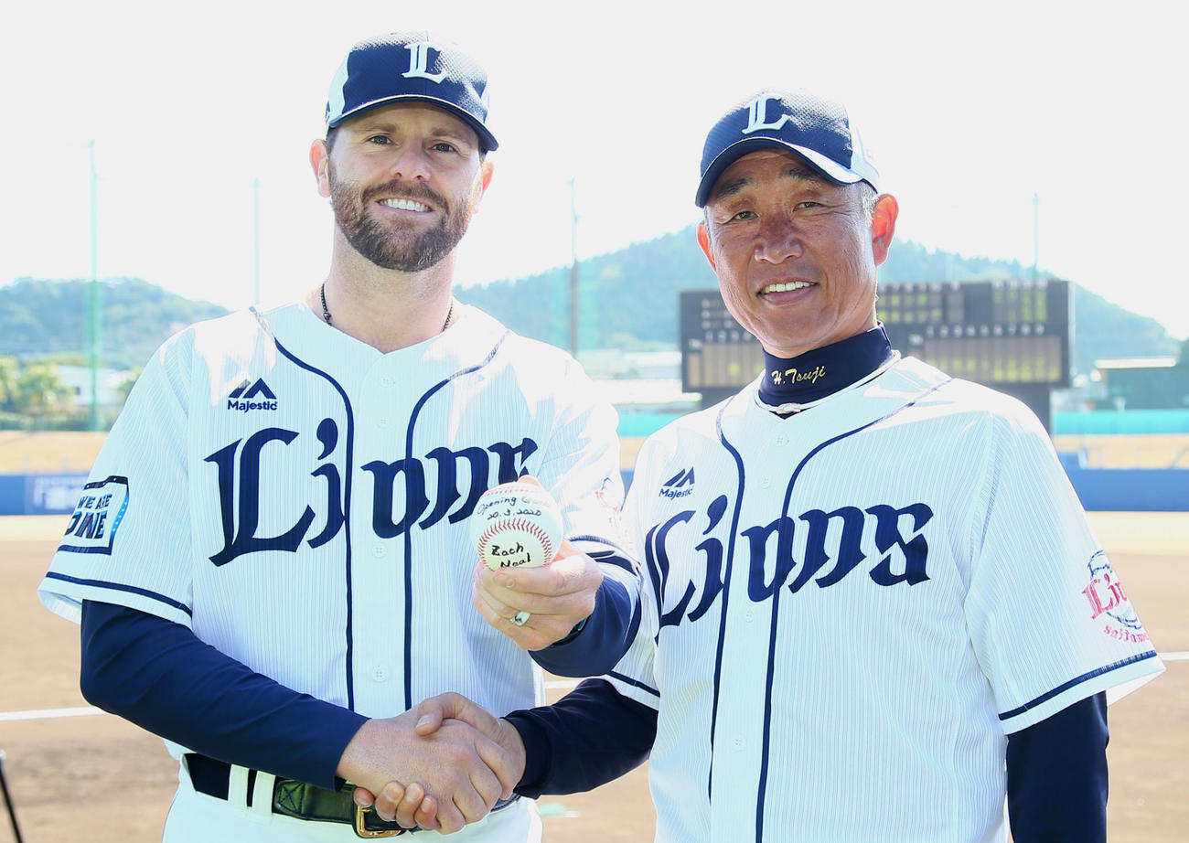 西武の開幕投手に決まったニール（左）は辻監督と笑顔で握手を交わす（2020年2月19日）