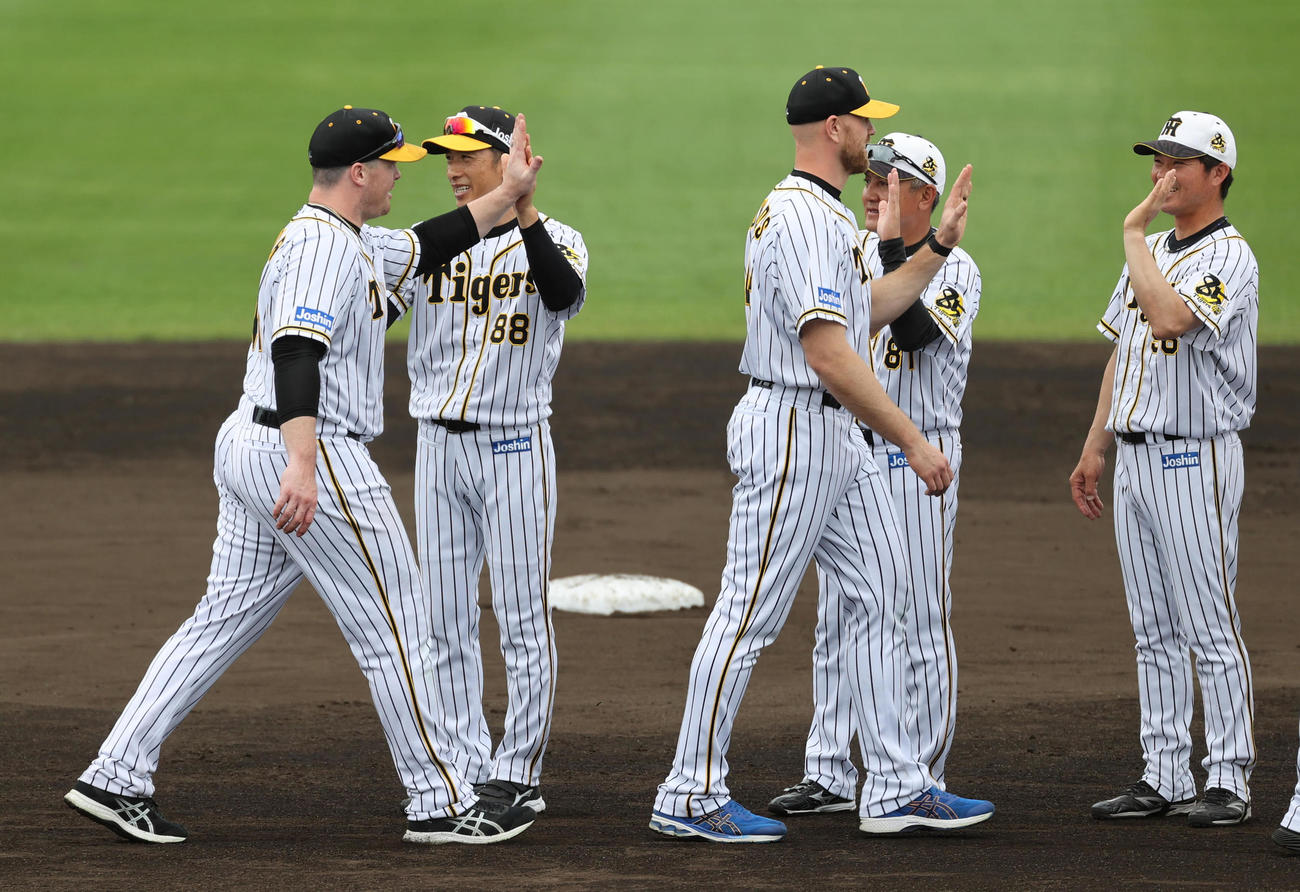 キャンプを打ち上げでボーア（左）、エドワーズ（左から3人目）らとタッチを交わす矢野監督（撮影・清水貴仁）
