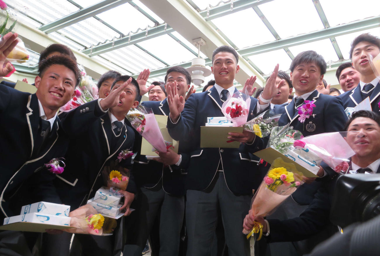創志学園高の卒業式を終えてチームメイトと記念撮影する阪神ドラフト1位の西純（中央）（撮影・磯綾乃）
