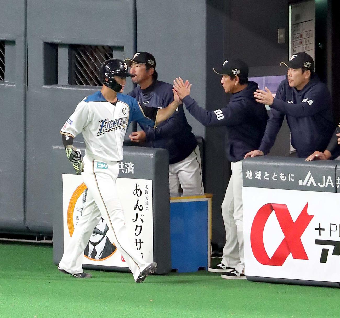 日本ハム対オリックス　6回裏日本ハム2死二塁、横尾の中前適時打で生還する西川（左）を出迎える栗山監督（撮影・佐藤翔太）