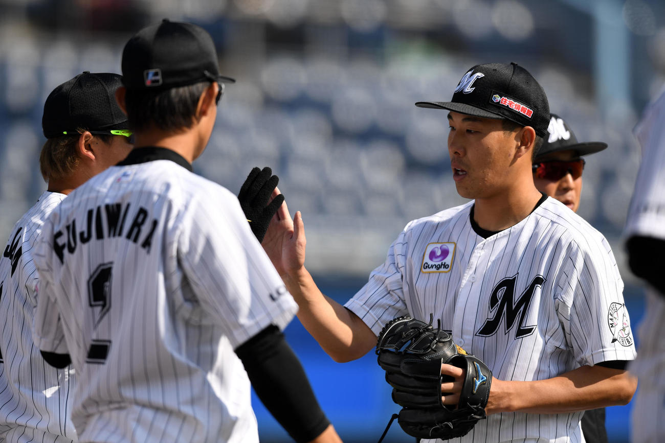 ロッテ対楽天　3回表を無失点に抑えナインとタッチを交わすロッテ西野（撮影・横山健太）