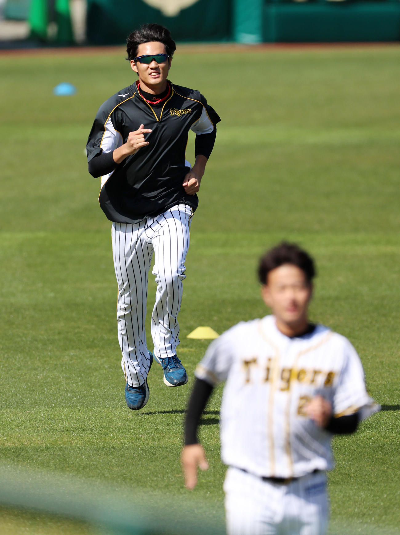 キャッチボールを終えた藤浪は外野でダッシュ。手前は高橋（撮影・加藤哉）