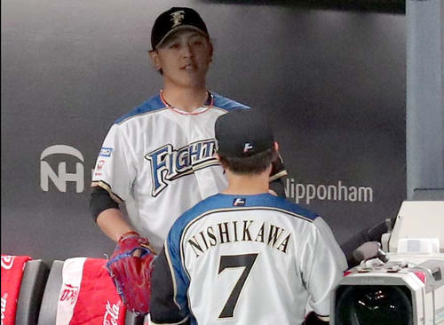 日本ハム対巨人　2回表を無失点でにえベンチで言葉を交わす日本ハム河野と西川（右手前）（撮影・佐藤翔太）