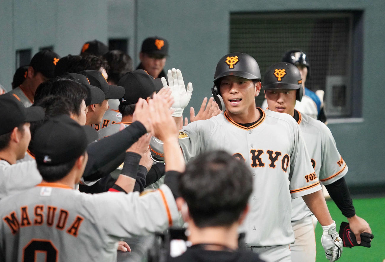 日本ハム対巨人　2回表巨人2死二塁、大城（手前）は中越えに先制の2点本塁打を放ち、走者岡本とベンチでナインに迎えられる（撮影・加藤諒）