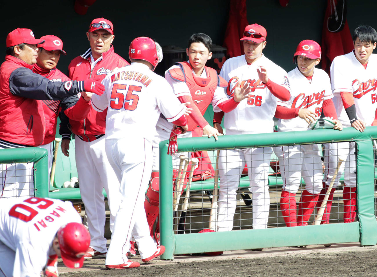 6回裏、松山は石原貴の適時打で生還しナインに迎えられる（撮影・加藤孝規）