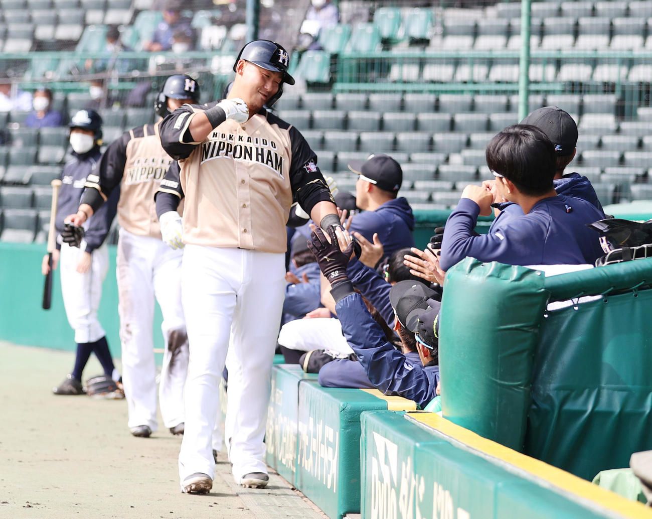2回表日本ハム1死一、三塁、右中間へ3点本塁打を放ちベンチの出迎えを受ける中田（撮影・清水貴仁）