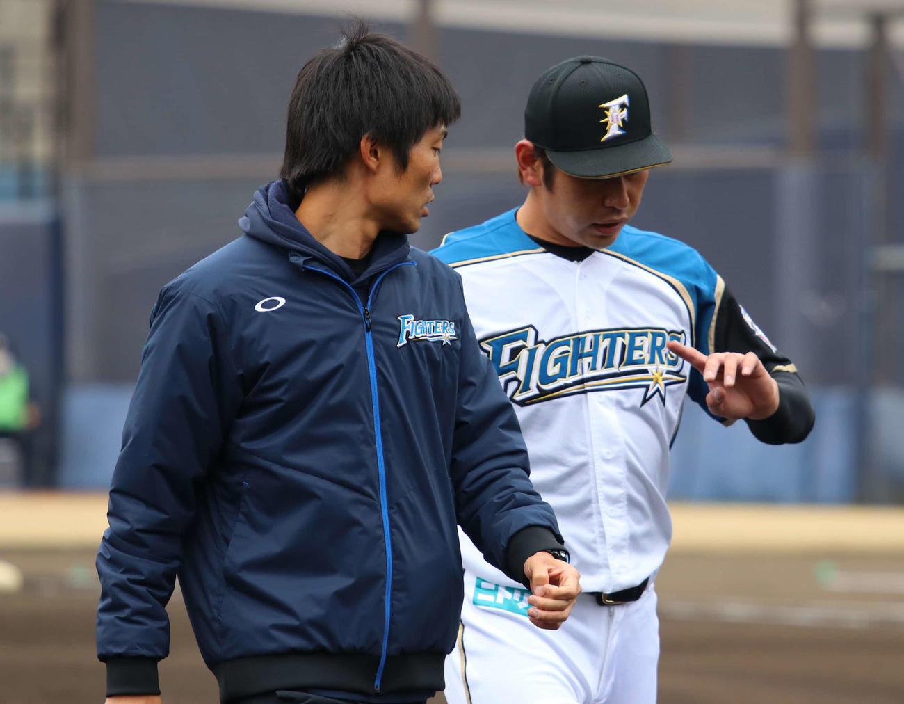 日本ハム対楽天　2回表楽天先頭の和田の打球が左手を直撃し、指先を気にしながらベンチ裏へと下がる日本ハム加藤（右）（撮影・山崎純一）