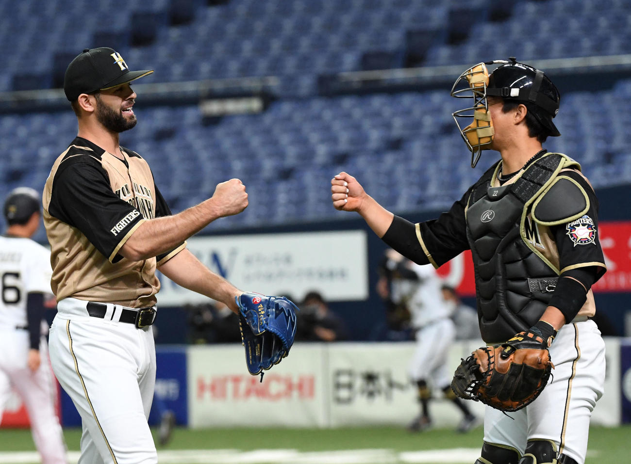 オリックス対日本ハム　6回、ベンチに戻るマルティネス（左）は鶴岡と笑顔でグータッチ（撮影・前岡正明）