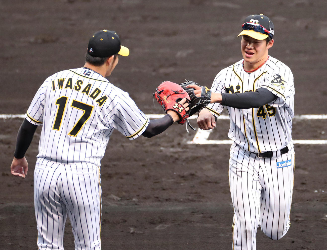 阪神対巨人　7回表巨人攻撃終了、好守を見せた遠藤は、岩貞（左）とグラブタッチ（撮影・清水貴仁）