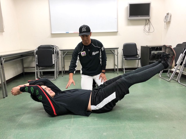 ゆりかごのような体勢で体幹トレを行うロッテ佐々木朗（手前）と菊地1軍ストレングスコーチ（球団提供）