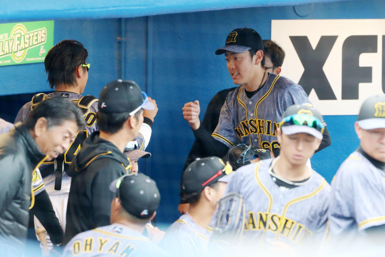 5回裏、阪神2番手で登板した小川は無失点ピッチングを披露しベンチで梅野（左）とタッチする（撮影・加藤哉）