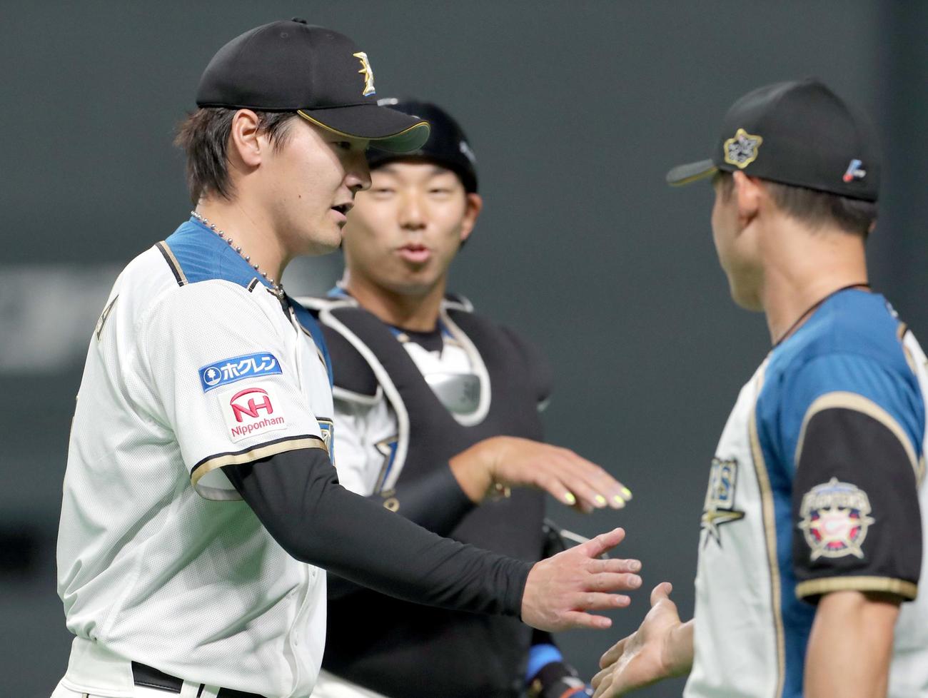 日本ハム対DeNA　日本ハム有原は杉谷（右手前）とタッチを交わしながらベンチに戻る（撮影・佐藤翔太）