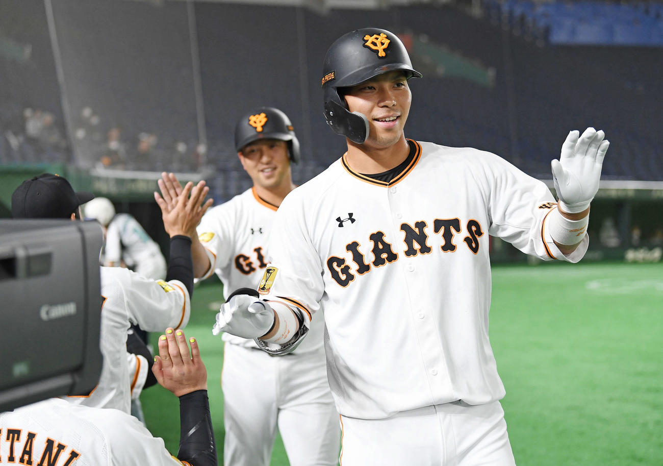 大城は右越えの2点本塁打を放ち、ベンチでナインに迎えられる。後方は走者中島（撮影・加藤諒）
