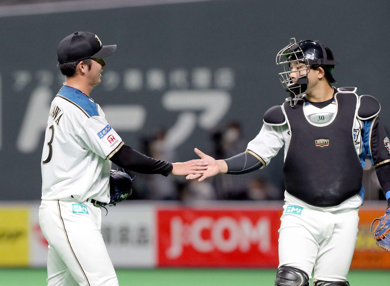 日本ハム対DeNA　9回表を無失点に抑えベンチに戻る日本ハム長谷川と宇佐見（右）（撮影・佐藤翔太）