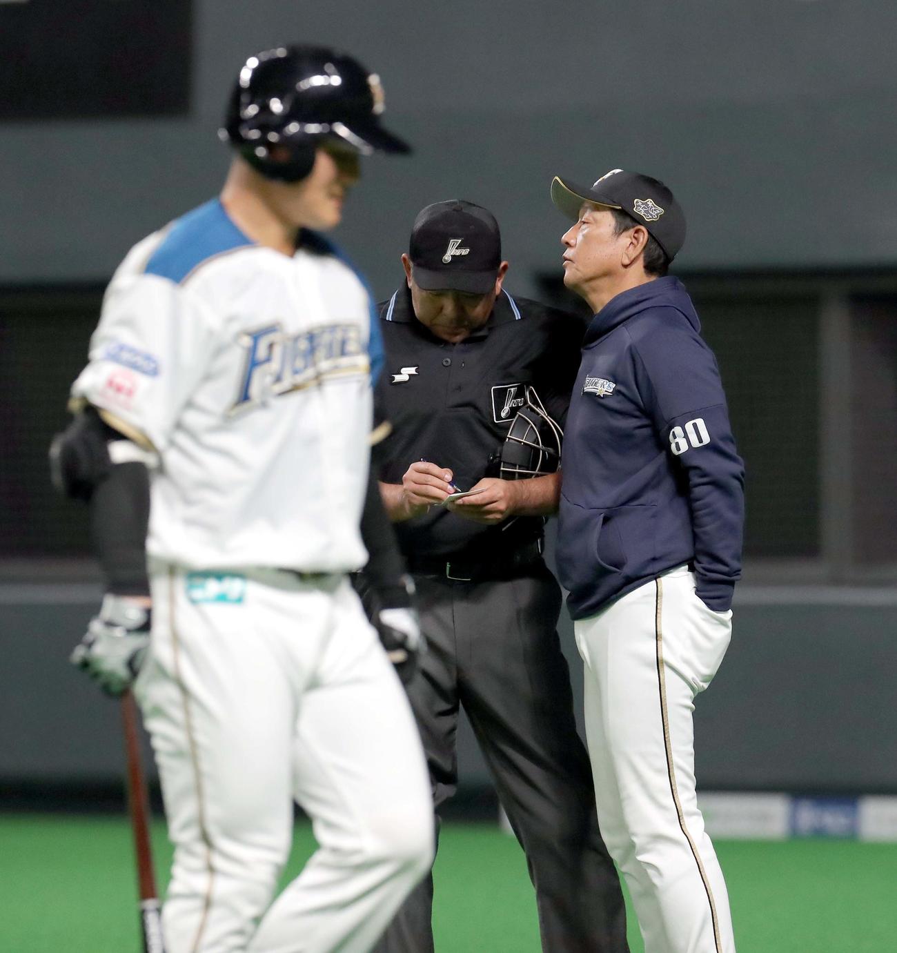 日本ハム対DeNA　選手交代を告げる日本ハム栗山監督（右奥）。左手前は三振に終わりベンチに戻る清宮（撮影・佐藤翔太）