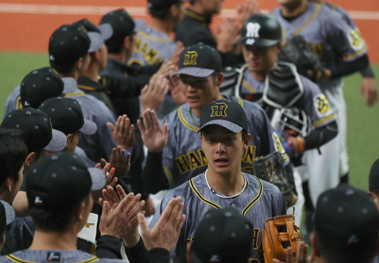 オリックス対阪神　オリックスに勝利し、タッチで迎えられる小幡（手前）ら阪神ナイン（撮影・前田充）