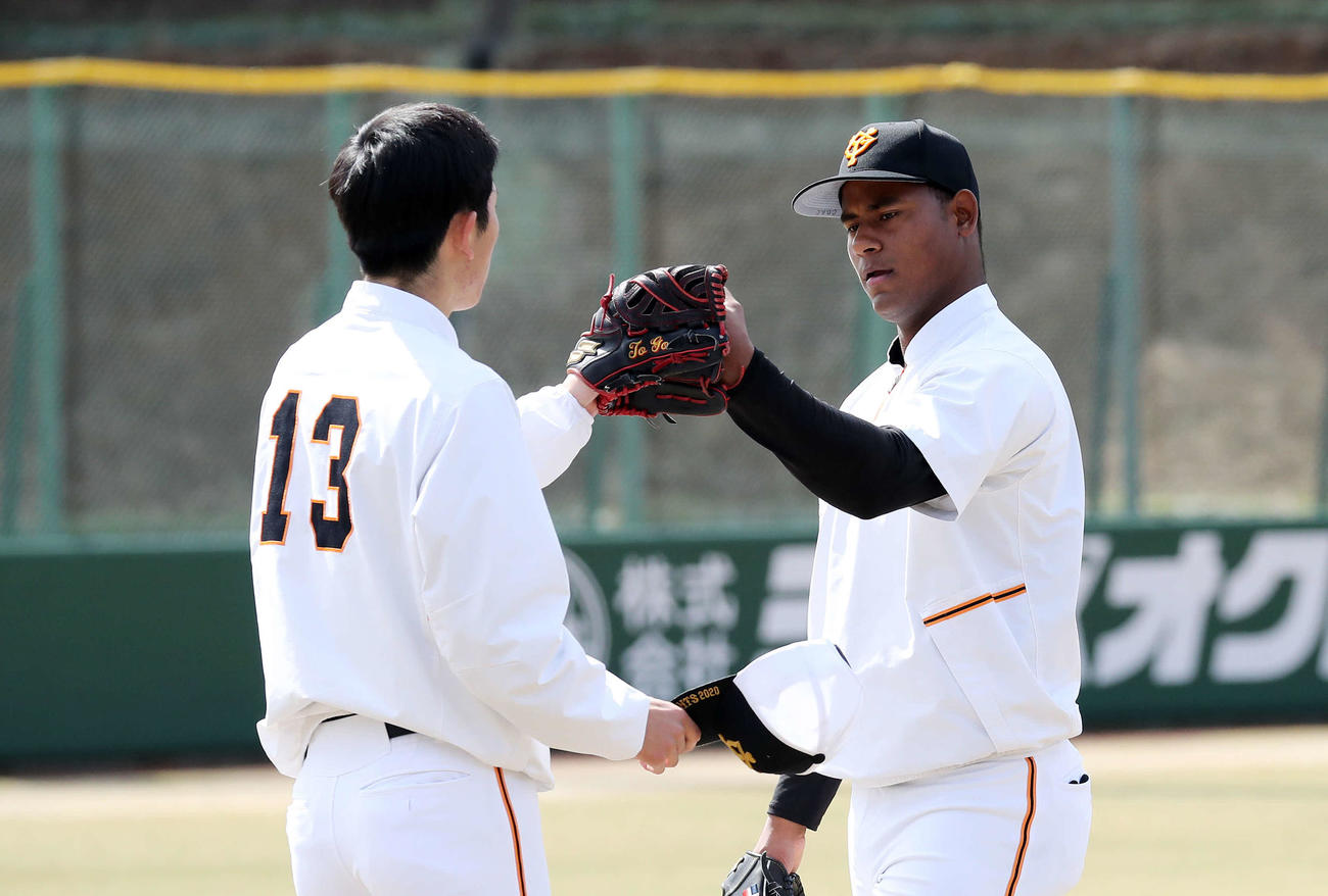 キャッチボールを終え、戸郷（左）とタッチする巨人メルセデス（撮影・鈴木正人）