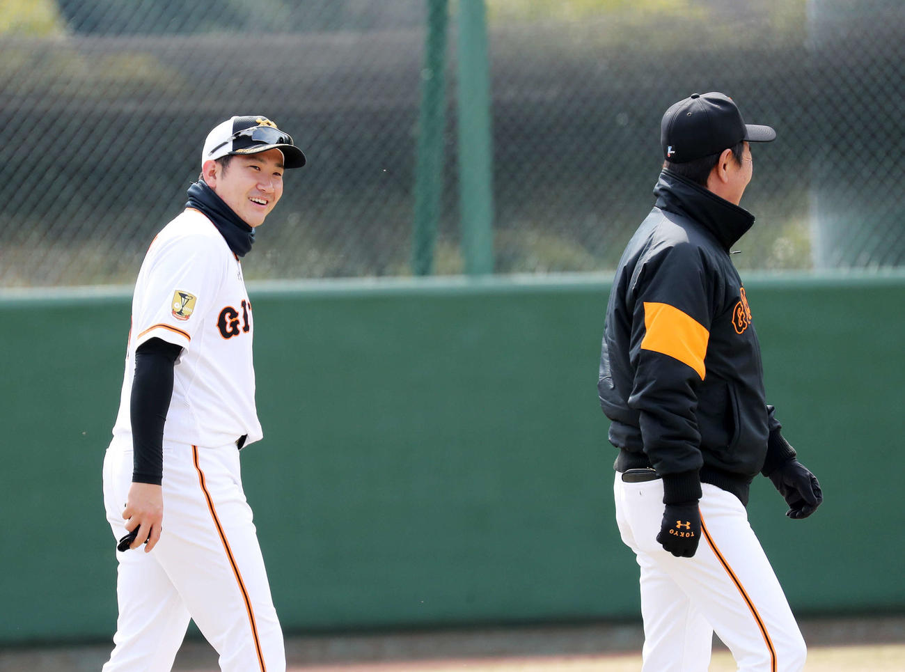 練習前、水野コーチ（右）と笑顔で話す巨人菅野（撮影・鈴木正人）