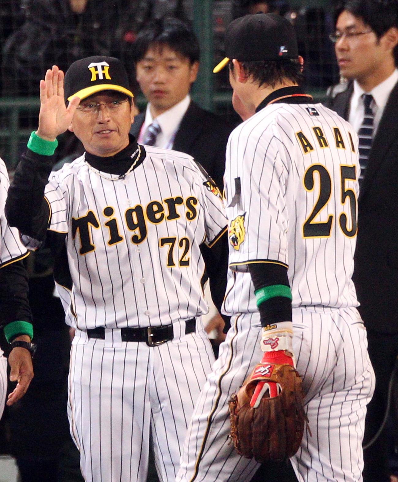11年4月12日、広島との開幕戦を白星で飾り真弓監督（左）は笑顔で新井貴浩を出迎える