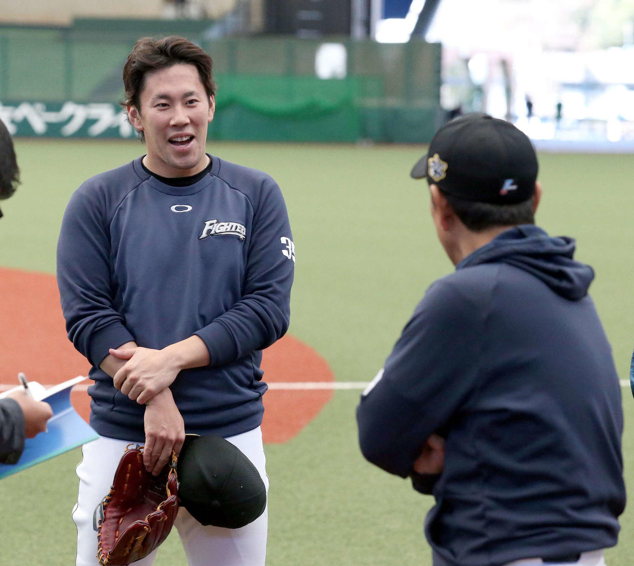 日本ハム西村（左）は栗山監督から声をかけられ笑顔を見せる（撮影・佐藤翔太）