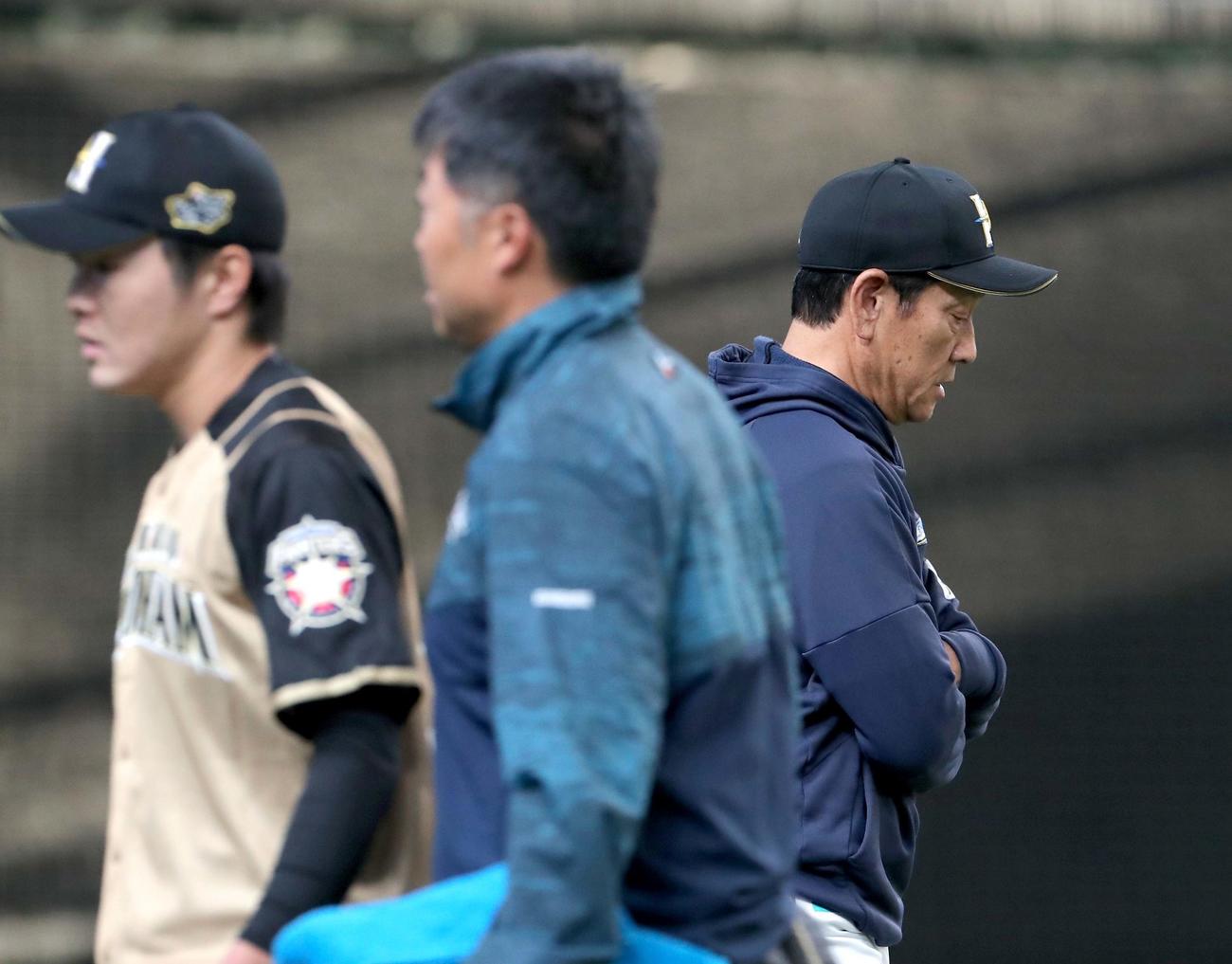 西武対日本ハム　選手交代を告げる日本ハム栗山監督。左手前はベンチに戻る玉井（撮影・佐藤翔太）
