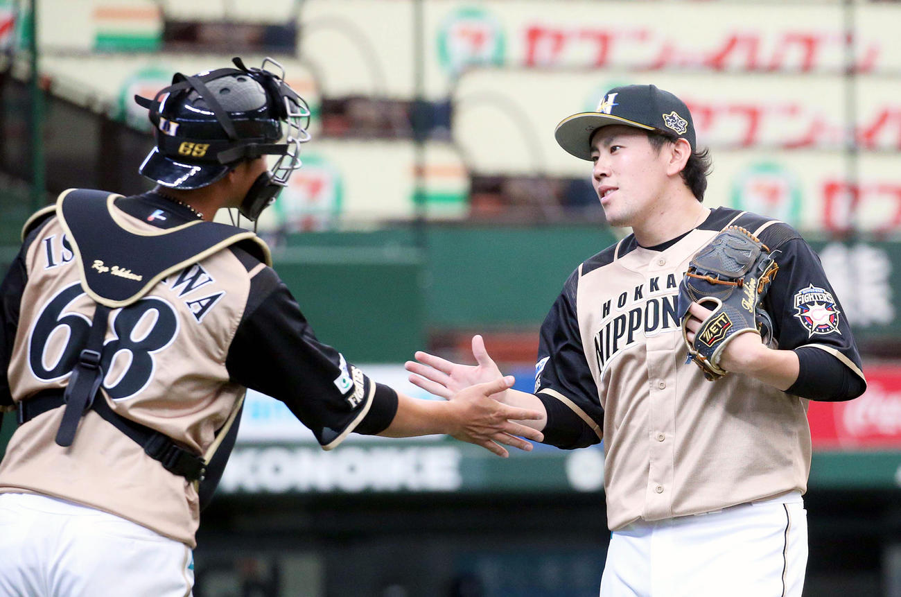 タッチを交わしながらベンチに戻る日本ハム石川亮と西村（右）（撮影・佐藤翔太）
