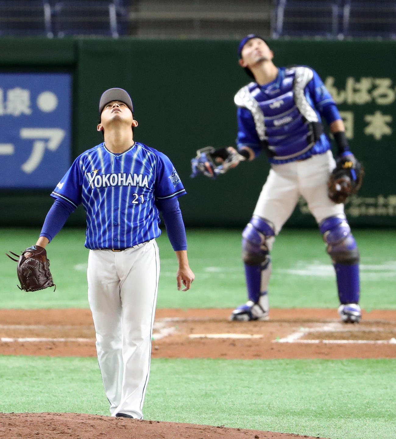 巨人対DeNA　4回裏巨人2死、岡本の天井に当たり三飛となる打球を見つめる今永（手前）と伊藤光（撮影・狩俣裕三）