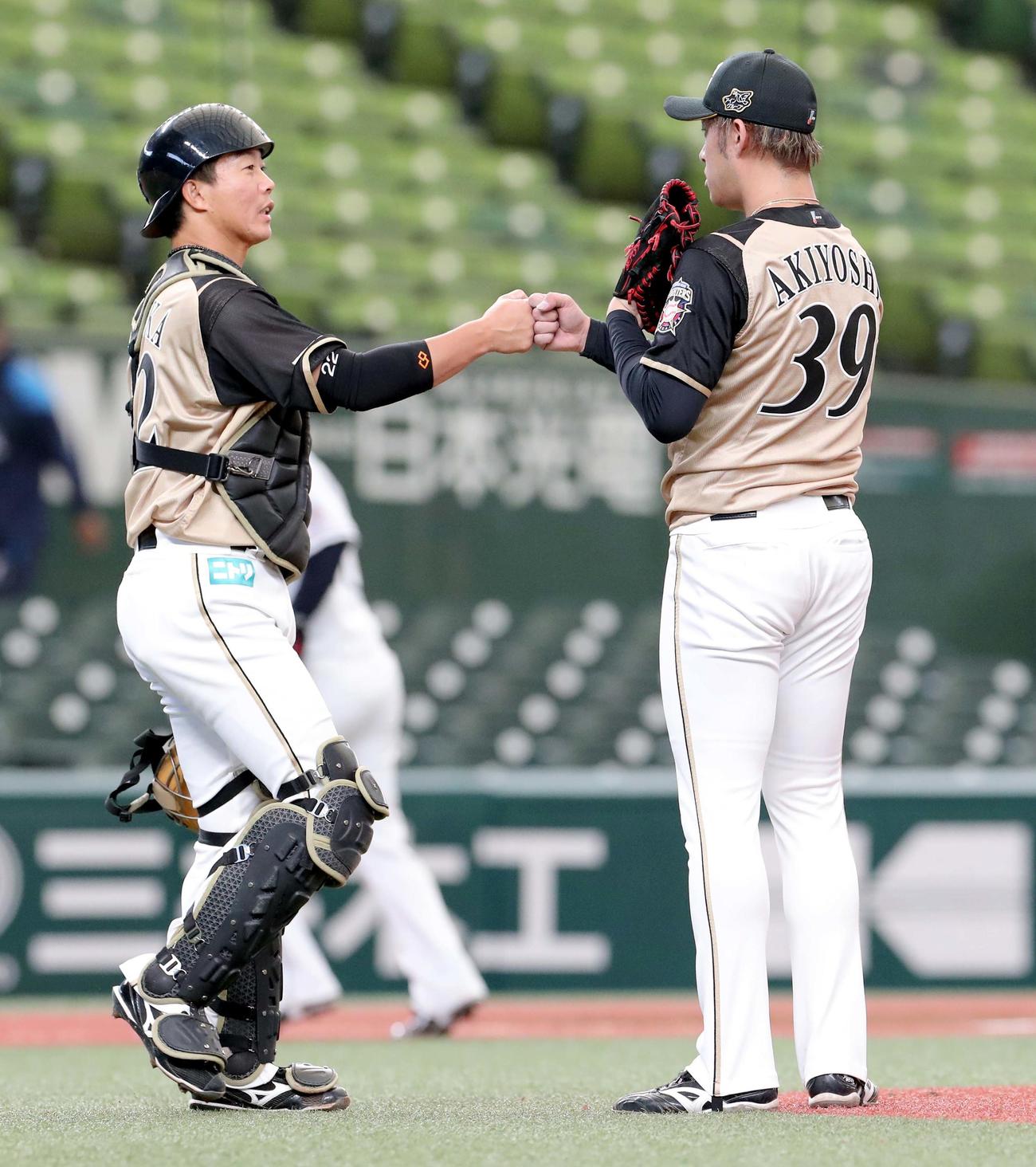 西武対日本ハム　試合終了後、グータッチをする日本ハム鶴岡と秋吉（右）（撮影・佐藤翔太）