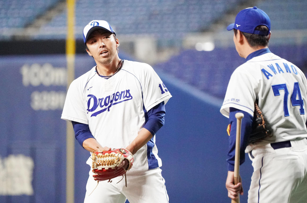投球練習後、阿波野秀幸投手コーチと話す吉見一起（左）（撮影・森本幸一）