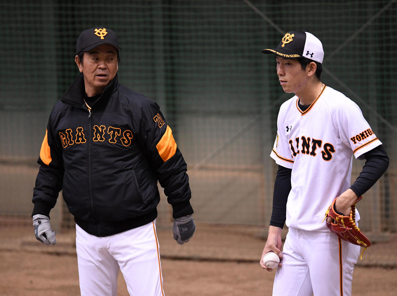 ブルペンで巨人水野コーチ（左）にアドバイスを受ける戸郷（撮影・横山健太）