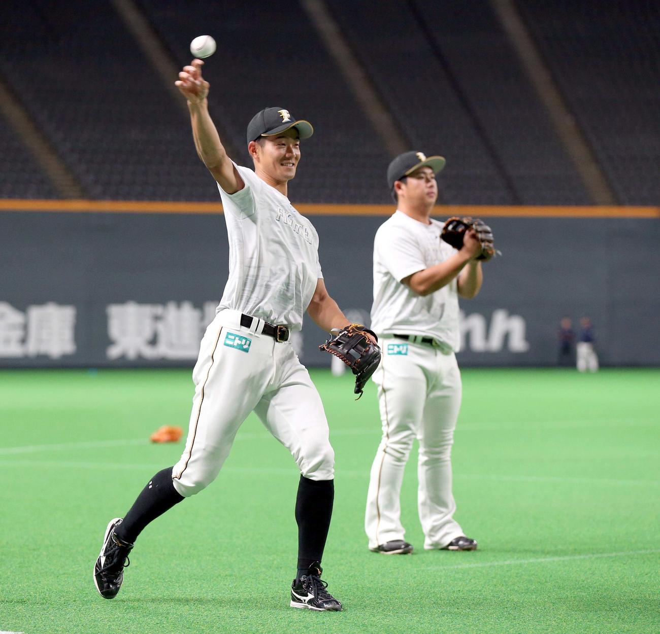 並んでキャッチボールする石井（左）と横尾（撮影・黒川智章）