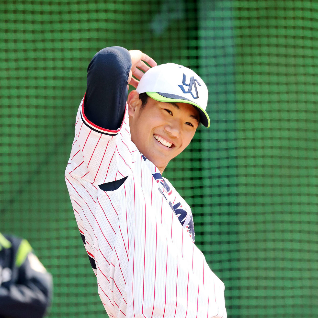 ブルペンで投球練習中、笑顔を見せるヤクルト奥川（撮影・鈴木正人）　