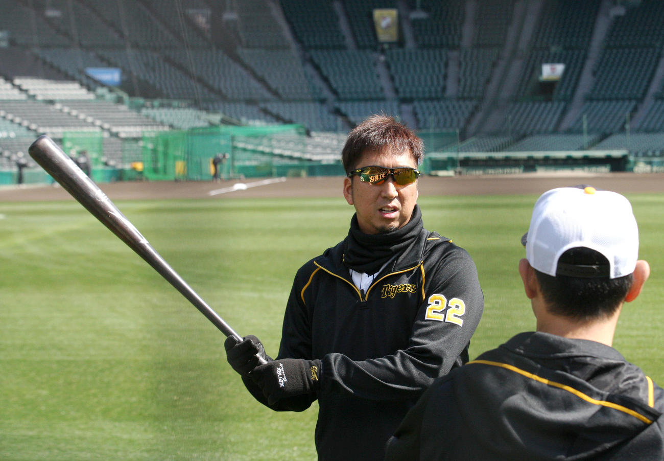 甲子園で練習する藤川はバットを持って金村投手コーチ（手前）と話す（撮影・上山淳一）
